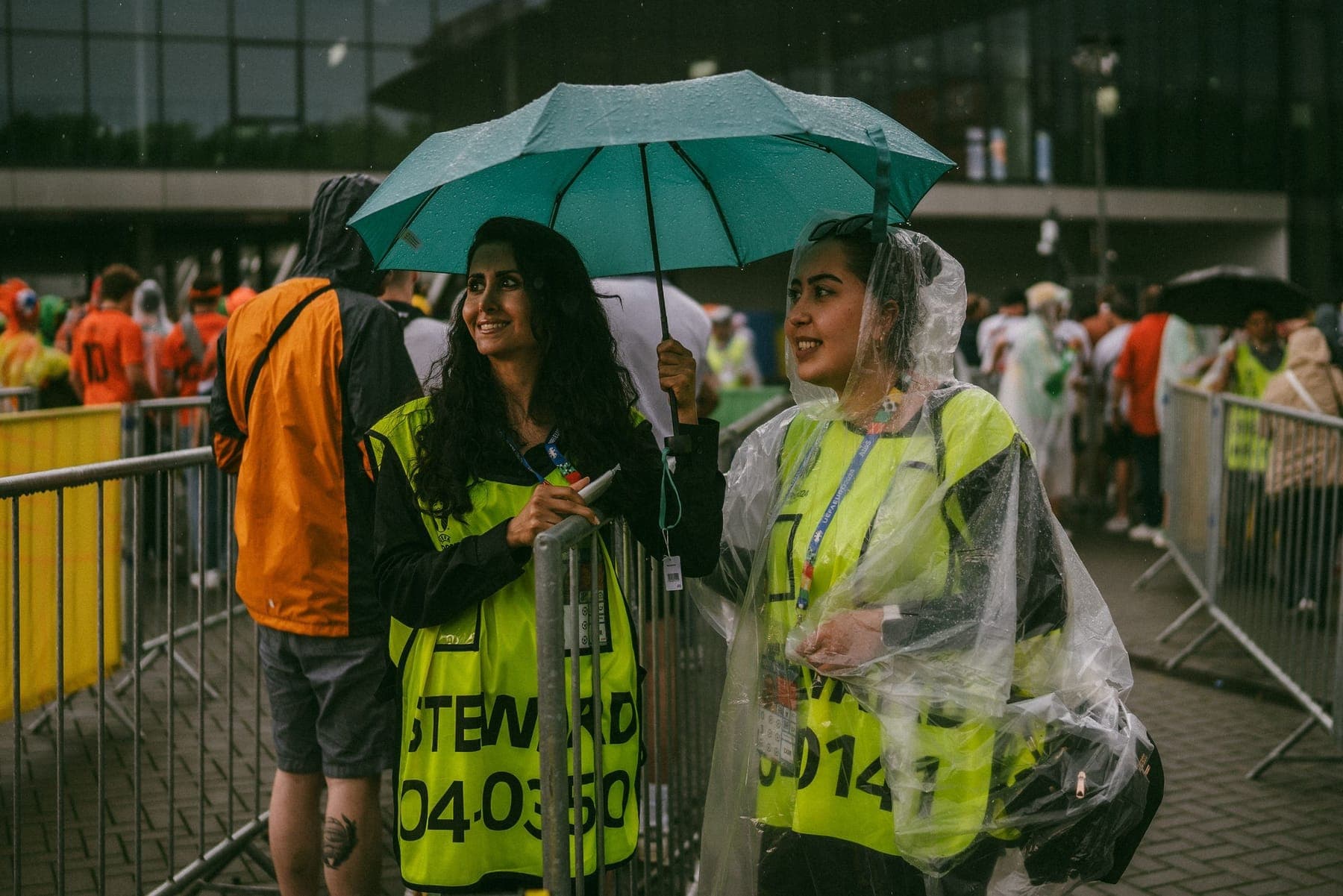 Two stewards in hi-vis jackets at a crowd barrier